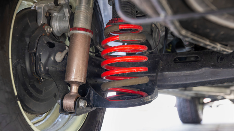 A red shock absorber on the underside of an SUV or MPV.