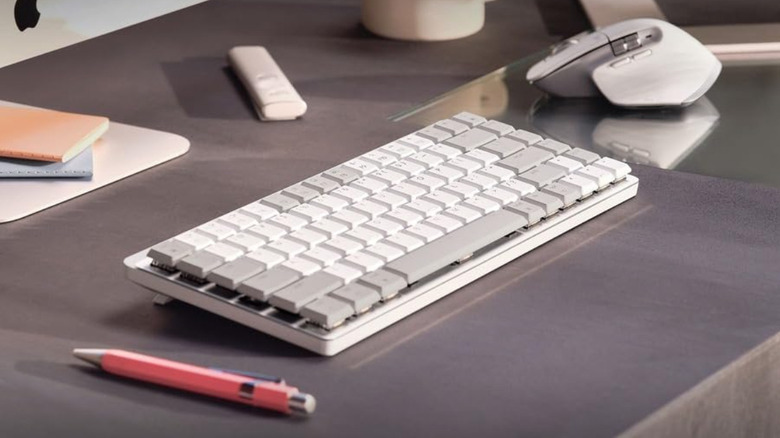 Logitech MX Mechanical Mini on a desk next to a mouse.