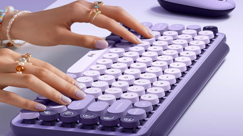 Hands tiping on th Logitech Pop Keys in purple.