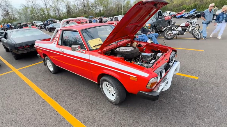 A first-generation 1978 Subaru Brat pickup crossover standing on pavement at a car show with its hood open.