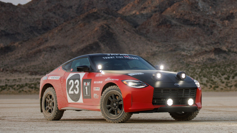 Nissan Safari Rally Z parked in the middle of a dry lakebed with all its lights on
