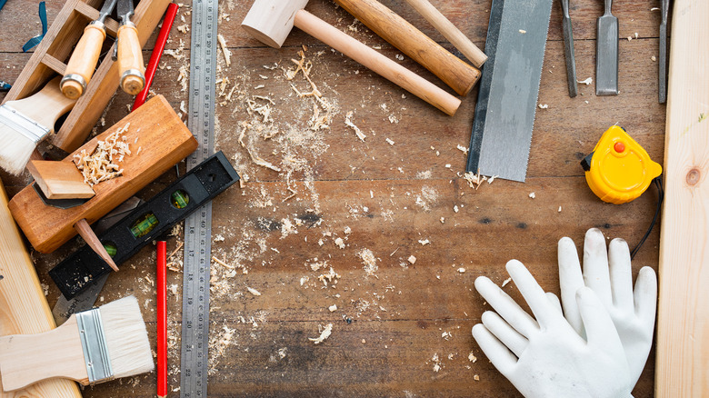 Collection of woodworking tools and gloves on a table