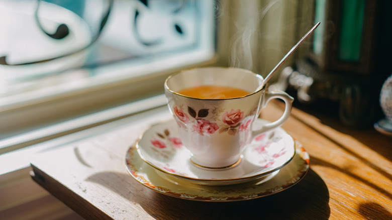 White china tea cup featuring roses on a matching saucer