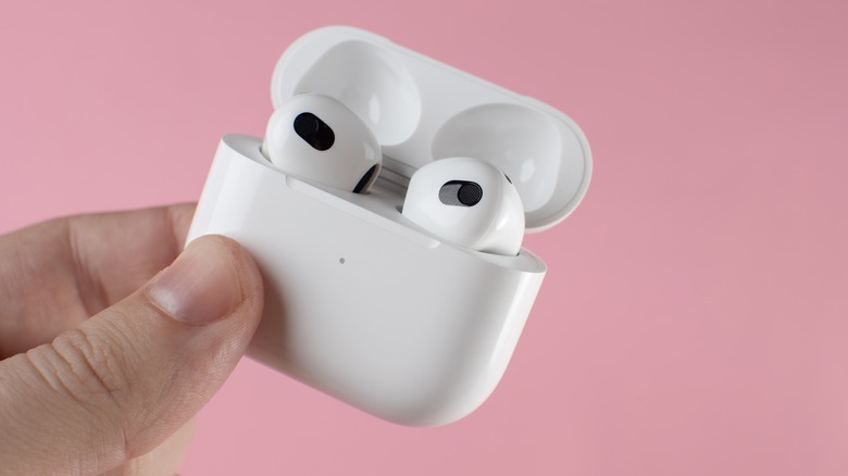 Holding a pair of AirPods 