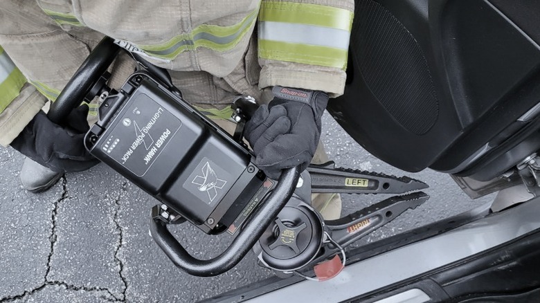 A firefighter working with a Power Hawk rescue tool.