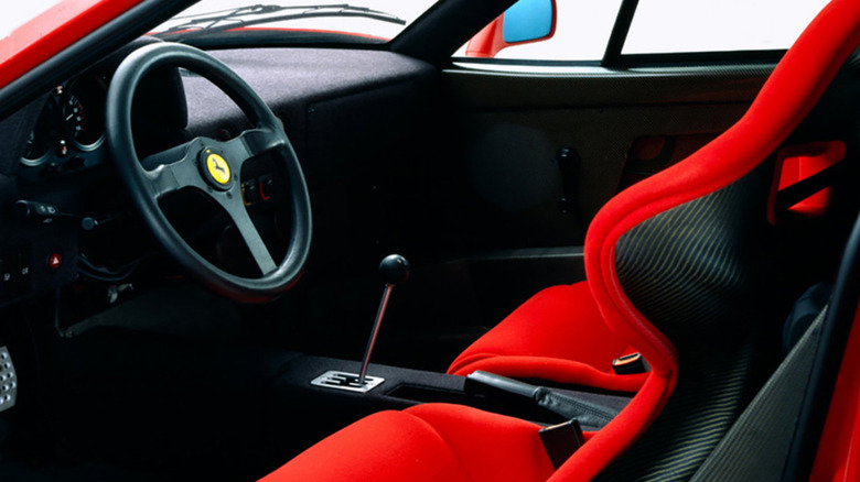 Ferrari F40 interior showing the steering wheel, seats, and gated manual transmission