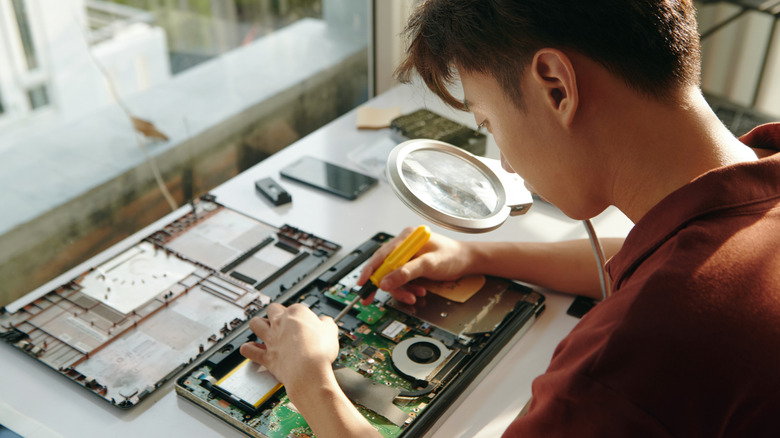 technician disassembling an electronic device