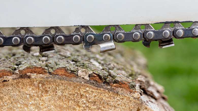 A loose chain on a chainsaw cutting through a log