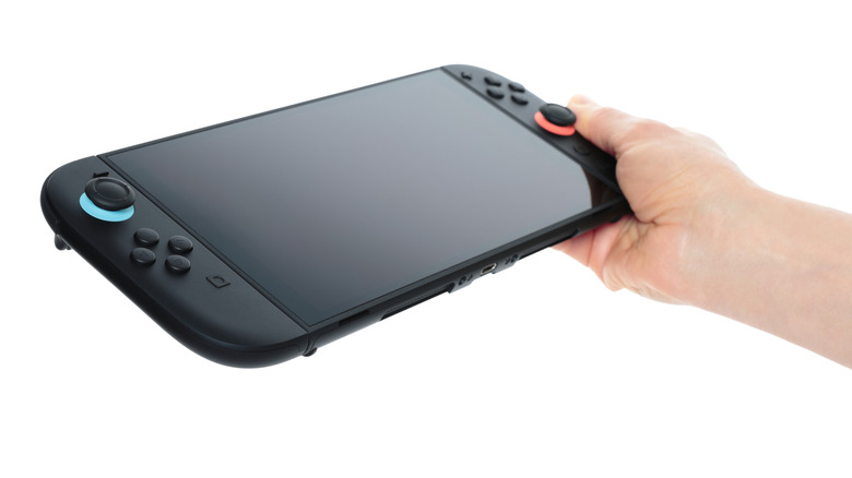 A person holding the Nintendo Switch 2 against a white background