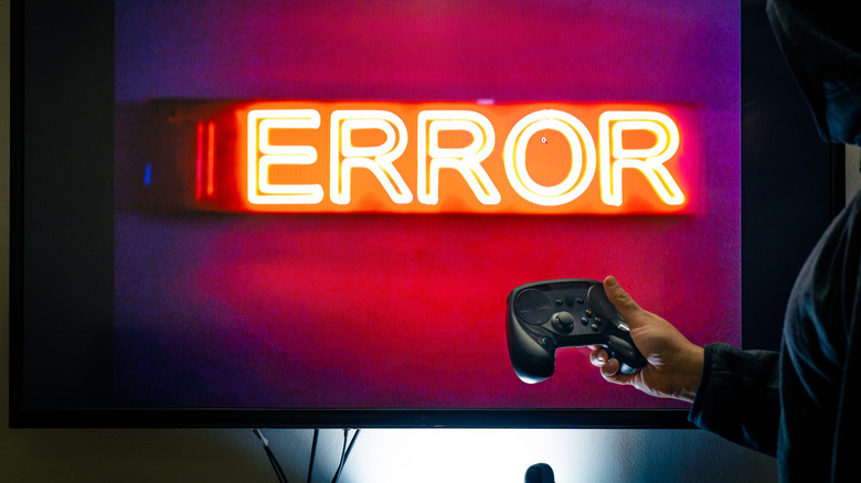 A person holding a controller in front of a screen showing an error message