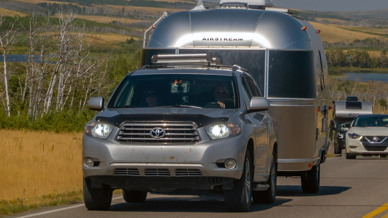 RV owners towing an Airstream on the highway