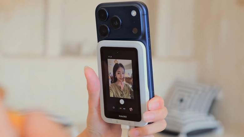 Woman taking selfie on an iPhone using the rear camera