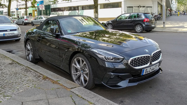 A black BMW Z4 parked on a curb in a town