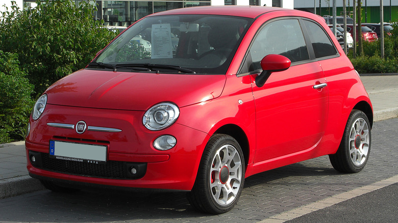 A red Fiat 500 parked on a city street