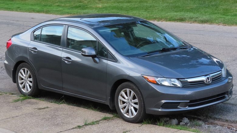 A dark gray 2012  Honda Civic parked on a street curb