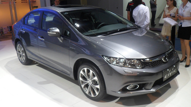 A silver Honda Civic on a showroom floor at an auto show
