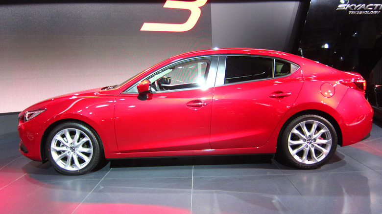 A red Mazda Mazda3 from the side
