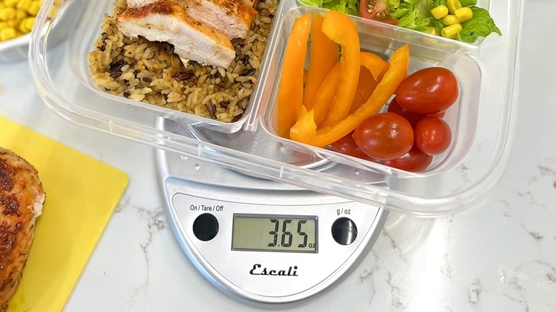 The Primo digital food scale with a full container filled with various types of food, and the weight displayed