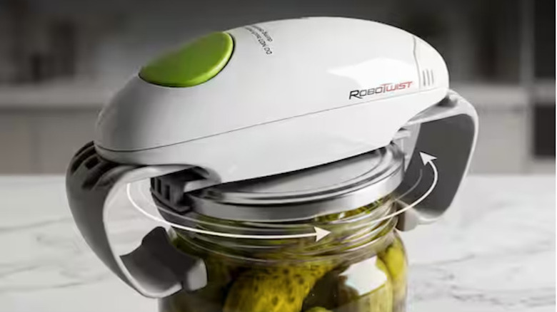 The Robo twist easy jar opener on top of a jar of pickles, rotating to open it