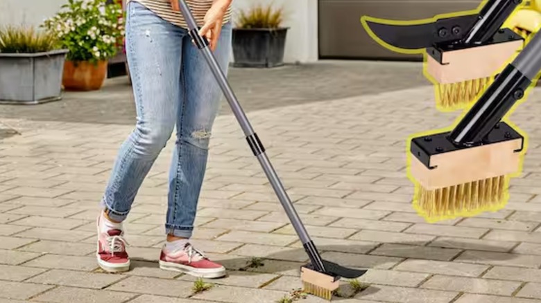An person scraping weeds on a brick patio with WaLensee brush tool