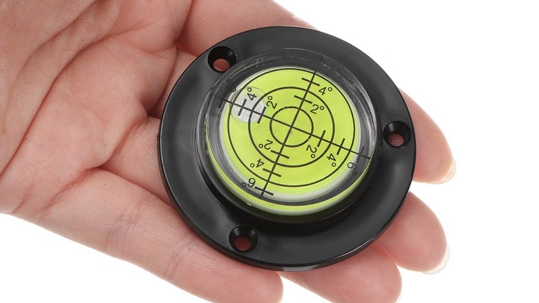Person holding multi-axes bubble level