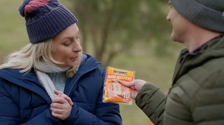 Person handing hand warmer to someone else