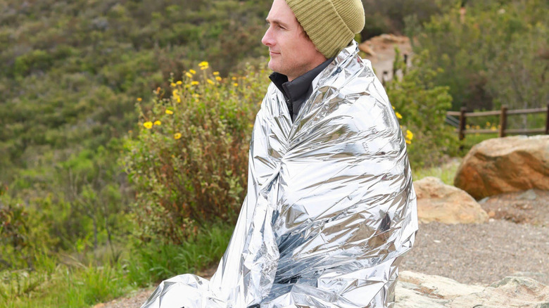 Person wearing emergency blanket