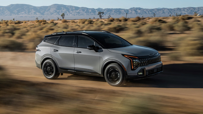A grey 2026 Kia Sportage driving through the desert