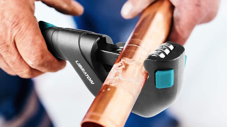 man cutting a pipe
