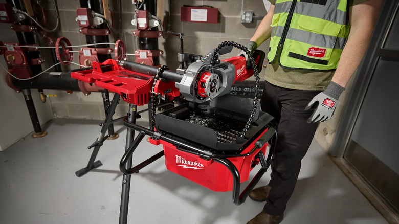 A brushless pipe threading oiler being used by someone in safety equipment.