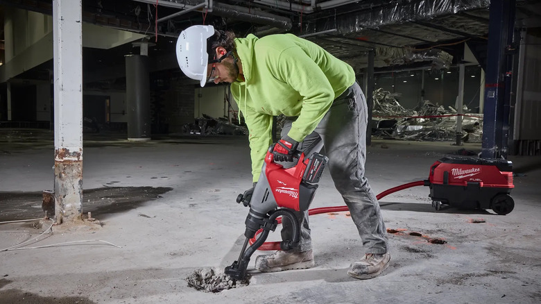 A max demolition hammer kit being used on the ground by someone in safety equipment.