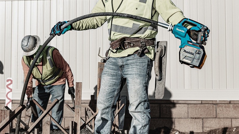 Person using Makita concrete vibrator