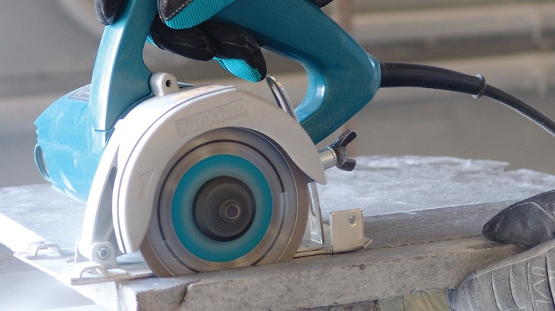 Close up person using Makita masonry saw