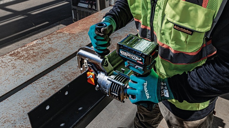 Person using Makita metal hole punch