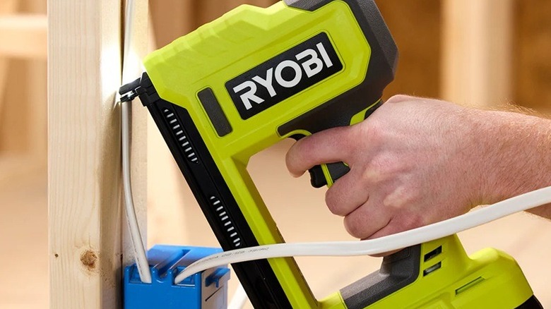 A person using the Ryobi cable stapler.