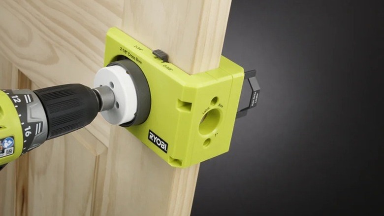Person using the Ryobi door lock installer with a drill.