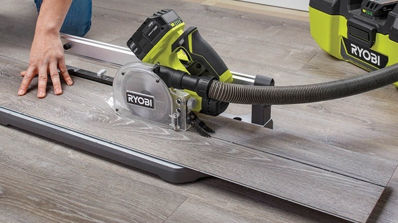 Person using Ryobi flooring cutter on a floor.