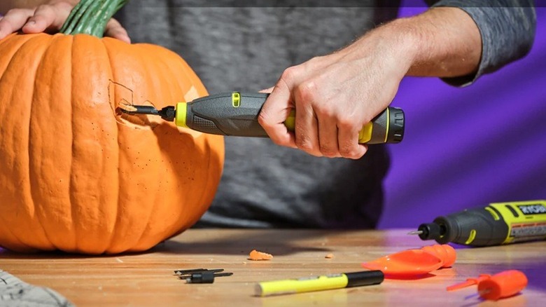 Person using Ryobi pumpkin carving kit on a pumpink.