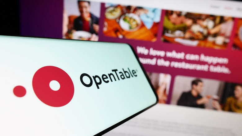 OpenTable app on smartphone with website in background