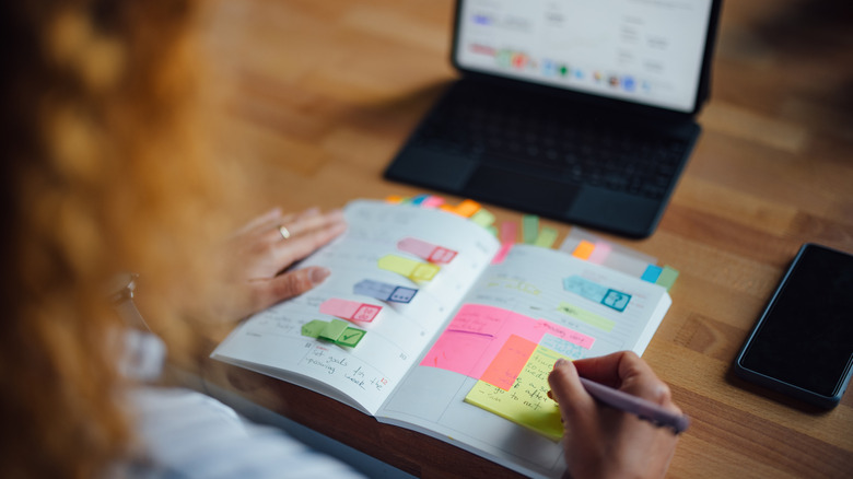 A peron budgeting with sticky notes and an iPad in the background