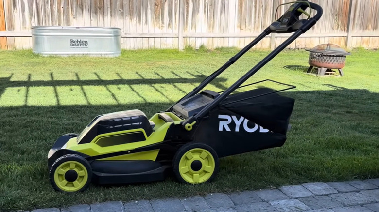 A Ryobi lawn mower parked on the grass
