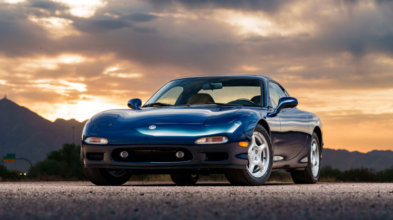 A front 3/4 shot of a blue 1994 Mazda RX-7 at sunset.