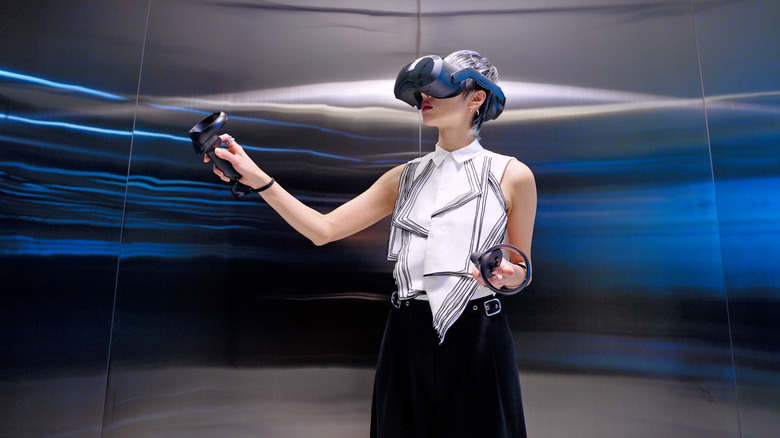 A person using the HTC Vive Focus 3 headset and controllers