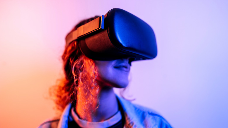 A person wearing a VR headset, bathed in neon light