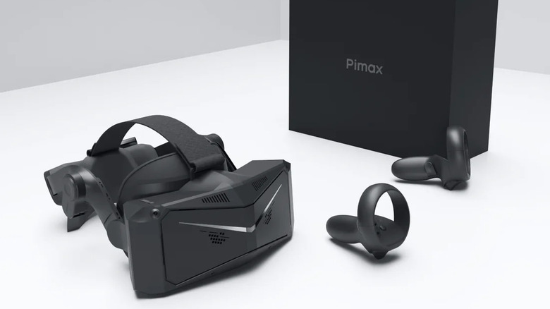 The Pimax Crystal Light headset and two controllers on a white surface, next to the black product box