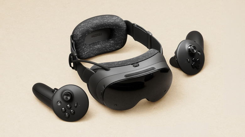 The Steam Frame VR headset and its two controllers on a beige background