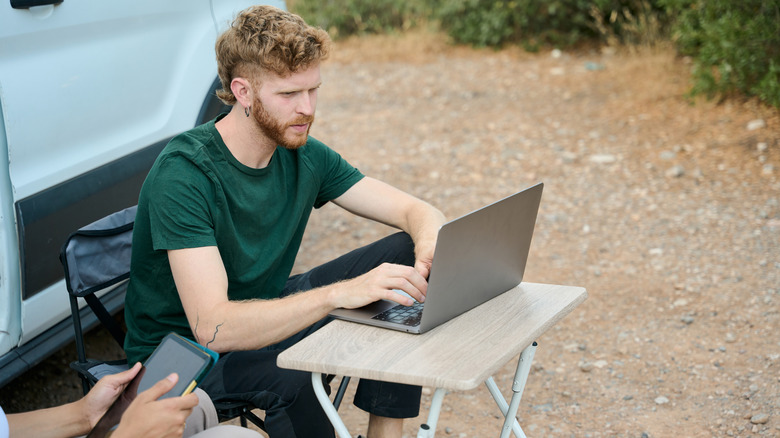 Person outside working on a laptop.