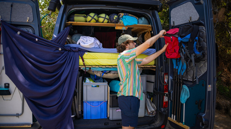 Person setting up camping gear in their van.