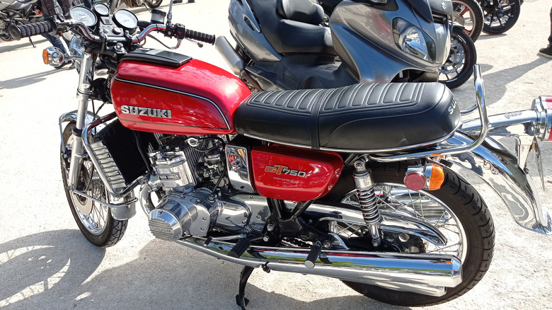 A red Suzuki GT750 being displayed at an auto show