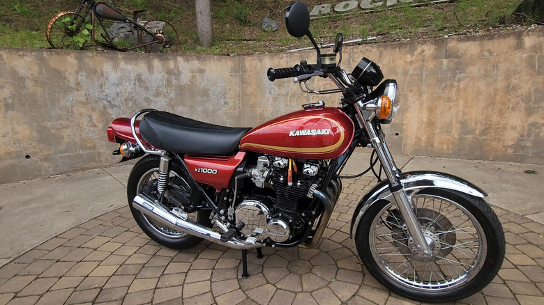 1978 Kawasaki KZ1000 motorcycle in red with chrome accents, parked on a stone-paved area.